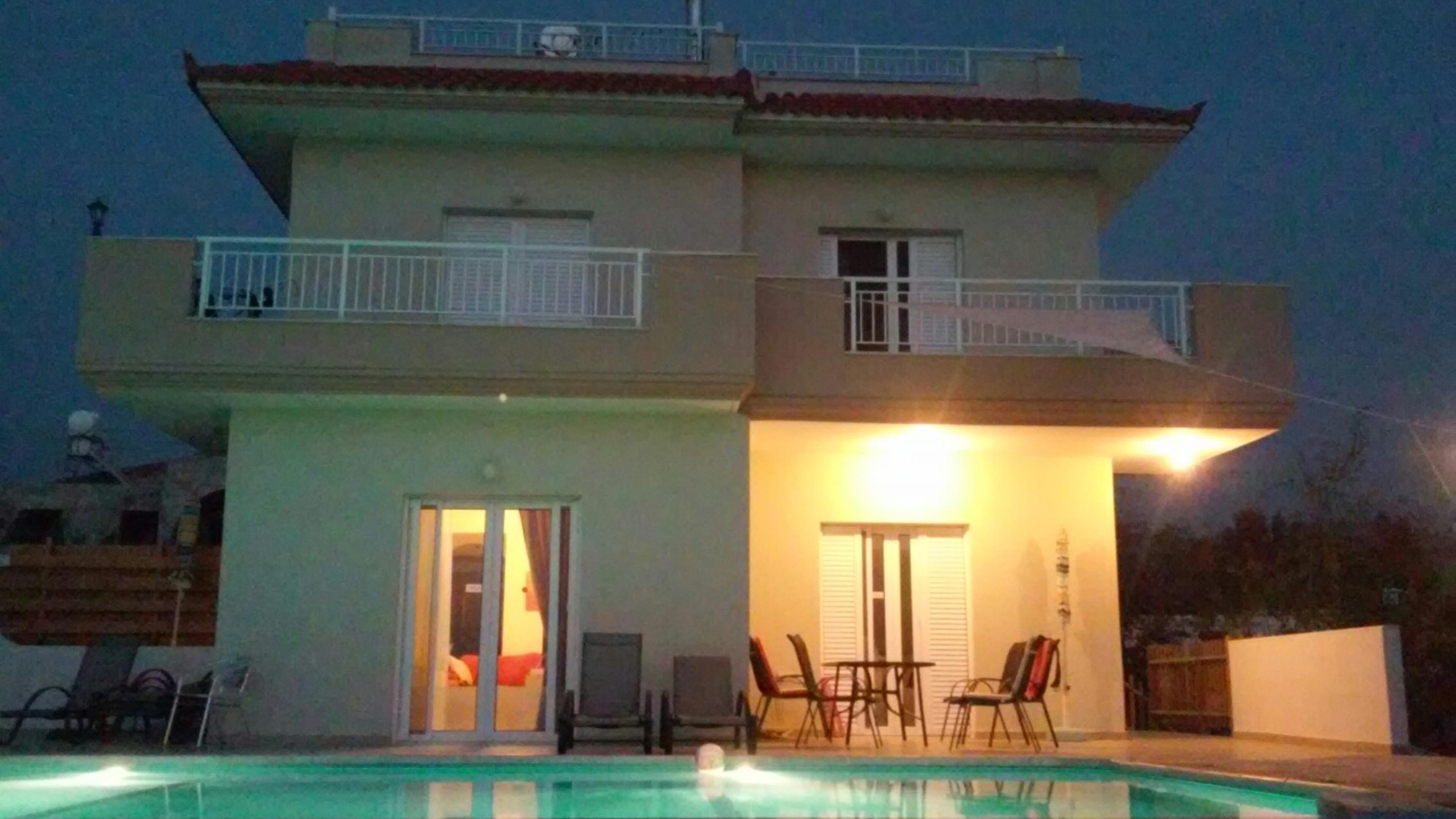 Η πισίνα και η βίλα τη νύχτα